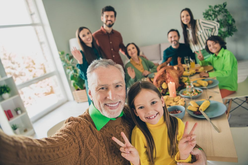 Multi-generational family smiling and alert at Thanksgiving dinner table showing benefits of good indoor air quality with ERV in Beacon NY home.