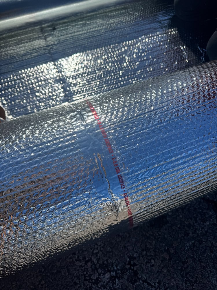 Duct insulation installed on HVAC ductwork using foil bubble wrap to prevent condensation